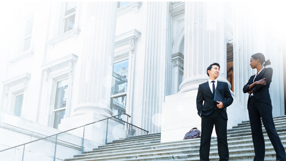 Offentlig upphandling En man och en kvinna i kostymer står på en trappa till en officiell byggnad